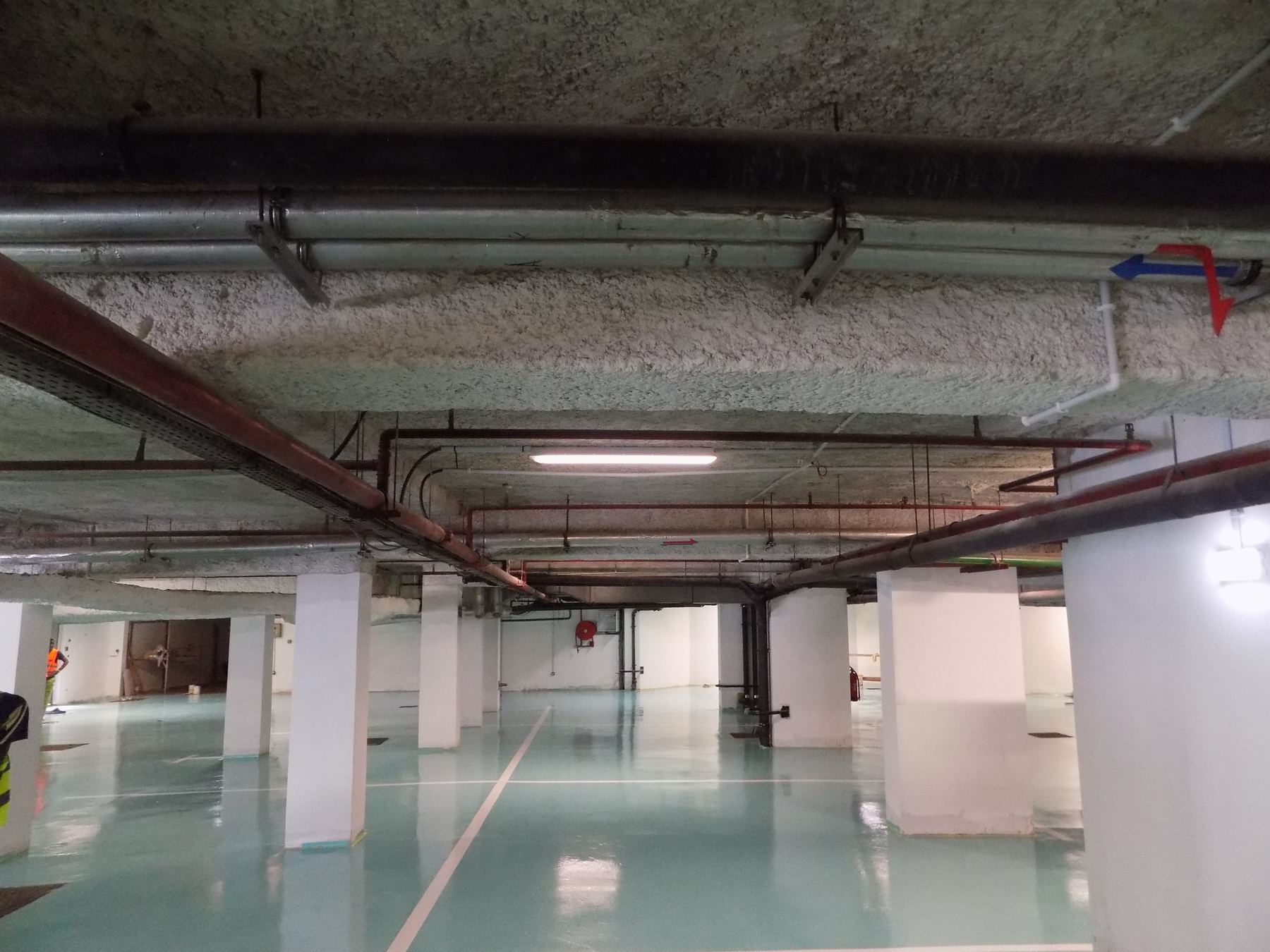 Parking souterrain au sol en résine époxy vert d'eau, avec marquage des places
